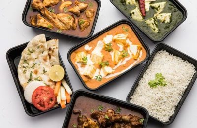 Online Food delivery concept Indian paneer butter masala and palak paneer, mutton & chicken curry with roti and rice in plastic containers, food like butter chicken, chicken